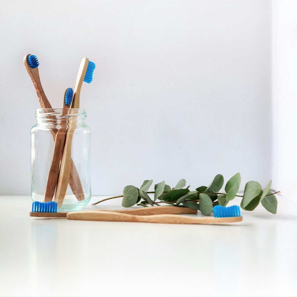 blue and white toothbrush in clear glass jar